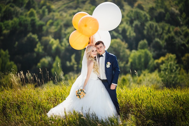 Wedding. Wedding day. Happy, smiling newlyweds with helium balloons having fun after wedding ceremony. Wedding concept. Marriage