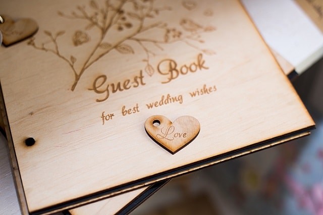 Un tavolo a un ricevimento di matrimonio con un guest book e un